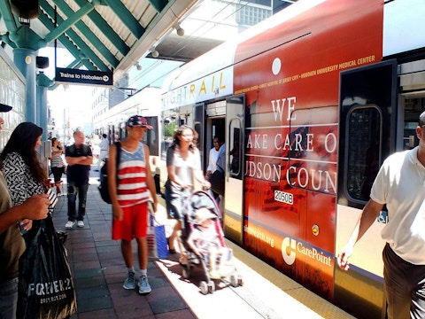 Commuters boarding NJ Transit train with CarePoint advertisement