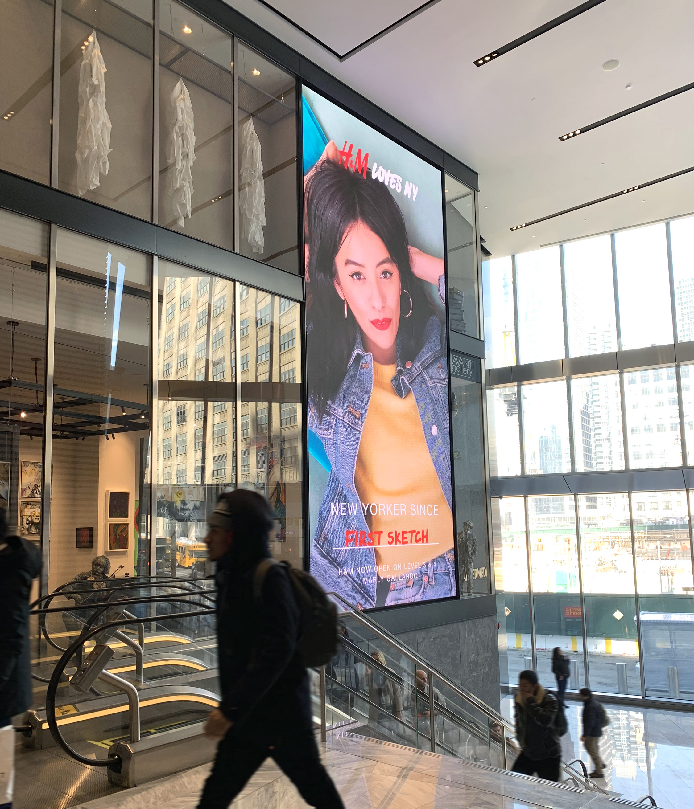Visitors walk by large format digital display at Hudson Yards
