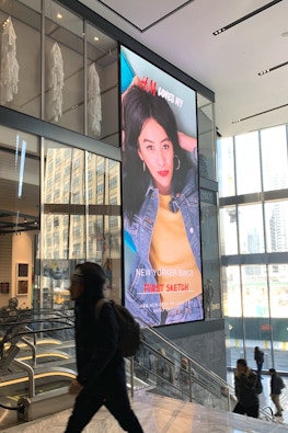 Visitors walk by large format digital display at Hudson Yards