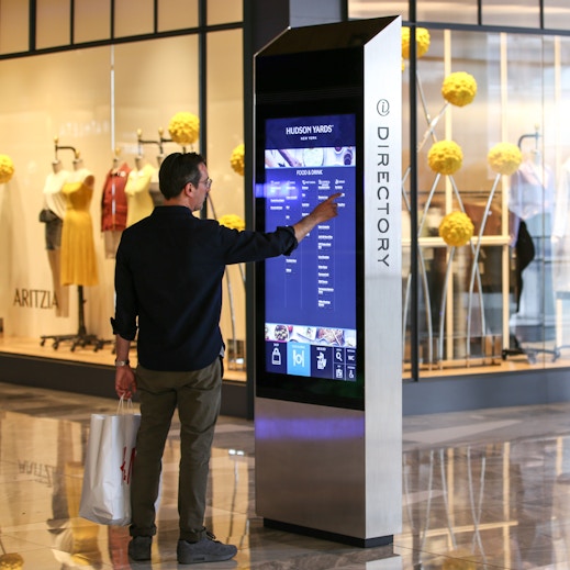 Shopper browses directory on IxNTouch kiosk at Hudson Yards