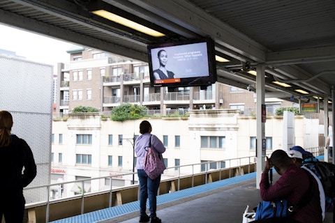 Rider looks at IxNSight display with advertising and arrival times in CTA