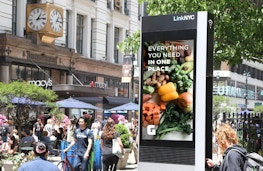 LinkNYC kiosk with retail brand mockup ad in front of Macy's in New York City - Digital Out of Home ad