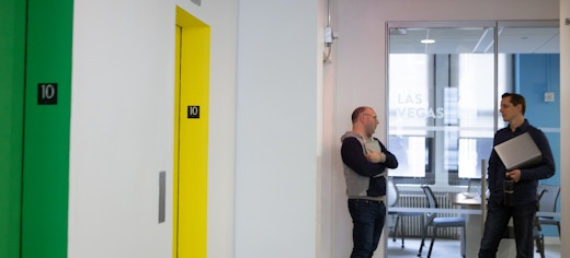 Intersection, Out of Home Media Company Office on Park Avenue with two office employees chatting next to conference room